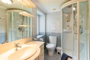a bathroom with a sink and a toilet and a shower at La Casona de Ilusión in Solórzano +12 photos