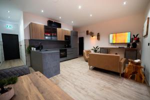 a living room with a couch and a table and a kitchen at LV8 Chesterfield in Chesterfield