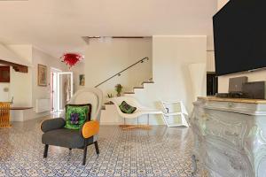 a living room with a chair and stairs at Villa Magnolie in Chioma