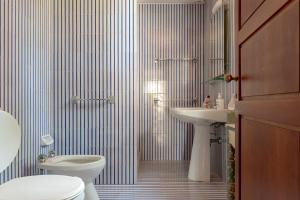 a bathroom with a toilet and a sink at Villa Magnolie in Chioma +26 photos