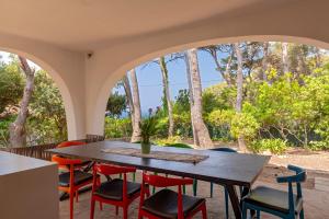 a table and chairs on a patio with trees at Villa Magnolie in Chioma