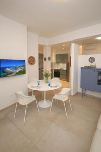 a living room with a white table and chairs at Appartamento Ralf - In Centro in Castelsardo +36 photos