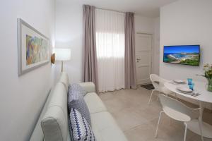 a living room with a white couch and a table at Appartamento Ralf - In Centro in Castelsardo