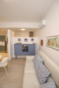 a living room with a white couch and a table at Appartamento Ralf - In Centro in Castelsardo