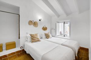 two beds in a bedroom with white walls and a window at Araucaria in Denia +25 photos
