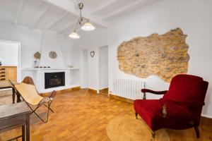 a living room with a fireplace and a red chair at Araucaria in Denia