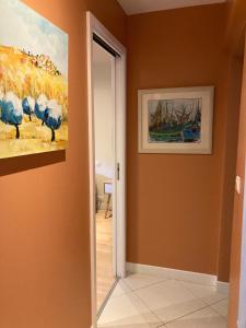 a hallway with a painting on the wall and a doorway at Chambre d'hotes La Rambleur in La Teste-de-Buch +2 photos