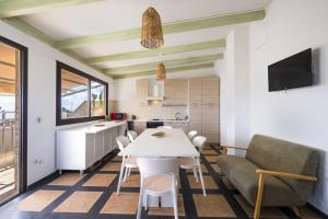 a kitchen and living room with a white table and chairs at Golden Bay Lux House in Torre Lapillo