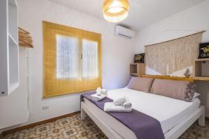 a bedroom with a bed with towels on it at Golden Bay Lux House in Torre Lapillo