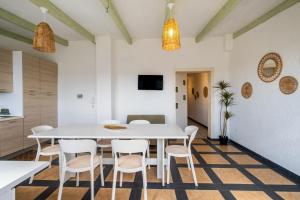 a kitchen and dining room with a white table and chairs at Golden Bay Lux House in Torre Lapillo