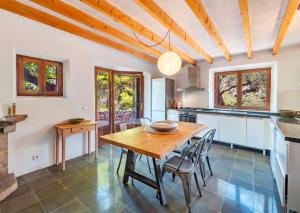 a kitchen and dining room with a wooden table and chairs at Sóller Es Cocó in La Figuera