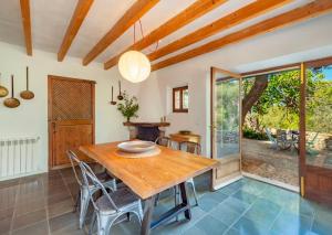 a dining room with a wooden table and chairs at Sóller Es Cocó in La Figuera +25 photos