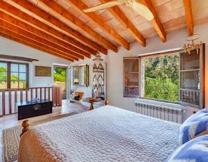 a bedroom with a large bed and a balcony at Sóller Es Cocó in La Figuera