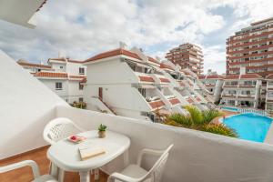 a balcony with a table and chairs and a pool at Infinity Pool Views 2 Las Floritas in Playa de las Americas