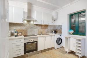 a white kitchen with a sink and a dishwasher at Sin Prisa, con Brisa in Costa Teguise +12 photos