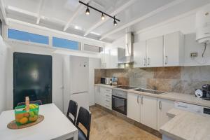 a kitchen with white cabinets and a table with a bowl of fruit on it at Sin Prisa, con Brisa in Costa Teguise