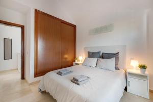 a bedroom with a large white bed with two towels on it at Sin Prisa, con Brisa in Costa Teguise