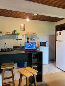 a kitchen with a desk with a laptop on it at Estúdio Confortável e Completo em Localização Privilegiada in Curitiba