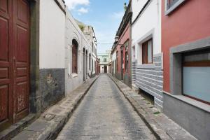 an alley with a cobblestone street in a city at Jardin Cardona in Arucas