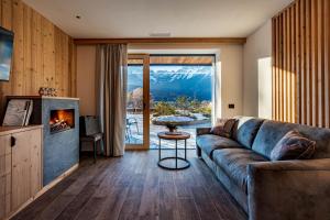 a living room with a couch and a fireplace at Arnica Alpin Lodge in Cavedago