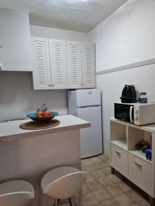 a kitchen with white cabinets and a bowl of fruit on a counter at Casita in Illes Balears