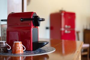 a red espresso machine sitting on a table at La Mansardina - Aosta in Aosta