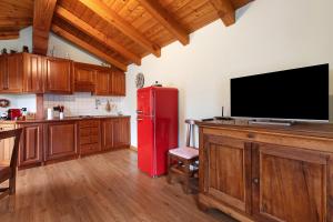 a kitchen with a red refrigerator and a flat screen tv at La Mansardina - Aosta in Aosta +24 photos