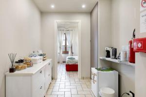 a kitchen with white cabinets and a room with a kitchen at B_B La Rugiada in Tigliole