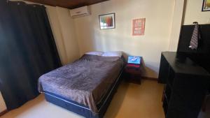 a small bedroom with a bed and a tv at Estúdio Confortável e Completo em Localização Privilegiada in Curitiba