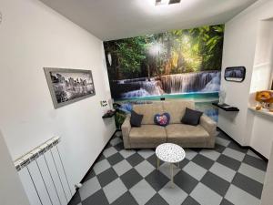 a living room with a couch and a waterfall painting on the wall at Genghetta in Rivotorto