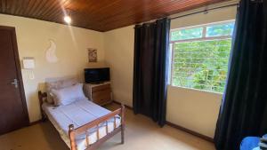 a bedroom with a bed and a large window at Estúdio Confortável e Completo em Localização Privilegiada in Curitiba