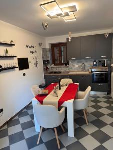 a kitchen with a red table and white chairs at Genghetta in Rivotorto +29 photos