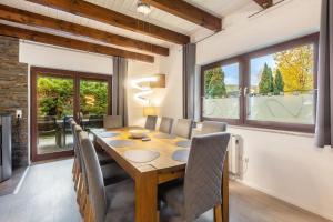 a dining room with a table and chairs and windows at Landhaus Sophie in Frielendorf