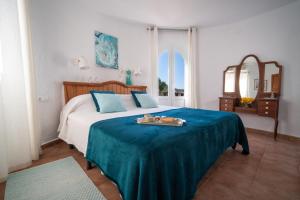 a bedroom with a bed with a blue blanket at Villa Torre Xanchu in Sant Josep de sa Talaia