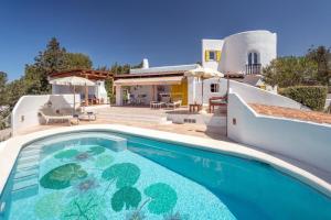 a villa with a swimming pool in front of a house at Villa Torre Xanchu in Sant Josep de sa Talaia