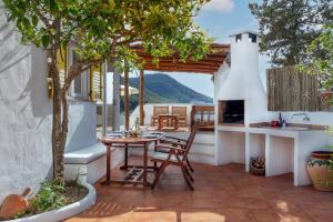 a patio with a table and chairs and a fireplace at Villa Torre Xanchu in Sant Josep de sa Talaia