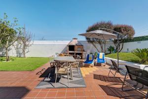 a patio with a table and chairs and a grill at Archer'shouse - Olival's Treasure in Olival