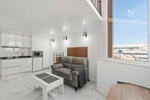 a living room with a couch and a table at Vima Lofts in Torrevieja