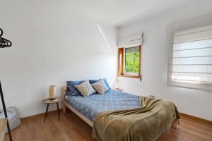 a bedroom with a bed with blue sheets and a window at Archer'shouse - Olival's Treasure in Olival +20 photos