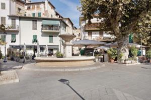 a fountain in the middle of a courtyard with a building at La casa tonda in Dolceacqua