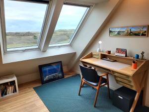 an attic room with a desk and two windows at Villa Des Havres in Saint-Germain-sur-Ay