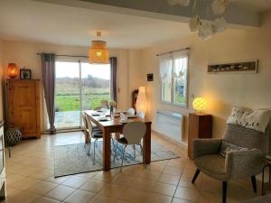 a living room with a dining room table and chairs at Villa Des Havres in Saint-Germain-sur-Ay