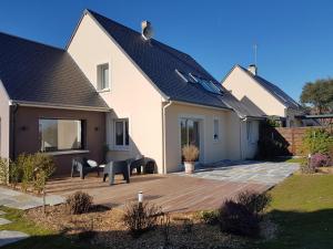 a house with a wooden deck in the yard at Villa Des Havres in Saint-Germain-sur-Ay