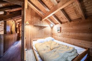a bed in a wooden room with wooden walls at Chalet 6p Classique - Les Gentianes in Verchaix
