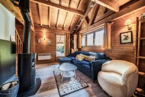 a living room with a blue couch and a fireplace at Chalet 6p Classique - Les Gentianes in Verchaix