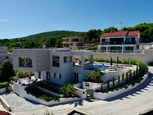 a large white house with a swimming pool at Villa Jasmina in Stomorska