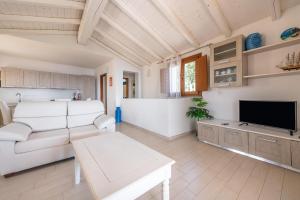 a living room with a couch and a tv at Villa Simonetta n9 in Costa Rei