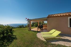 a house with a patio with a table and chairs at Villa Simonetta n9 in Costa Rei