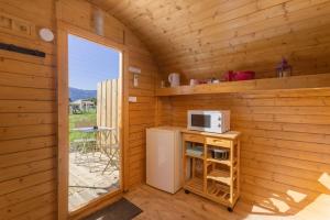 eine kleine Küche in einer Holzhütte mit Mikrowelle in der Unterkunft Barrel Violet in Saint-André