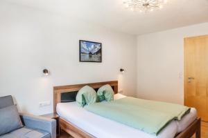 a bedroom with a bed and a chair at Haus Florian Ski-in and Ski-out in See